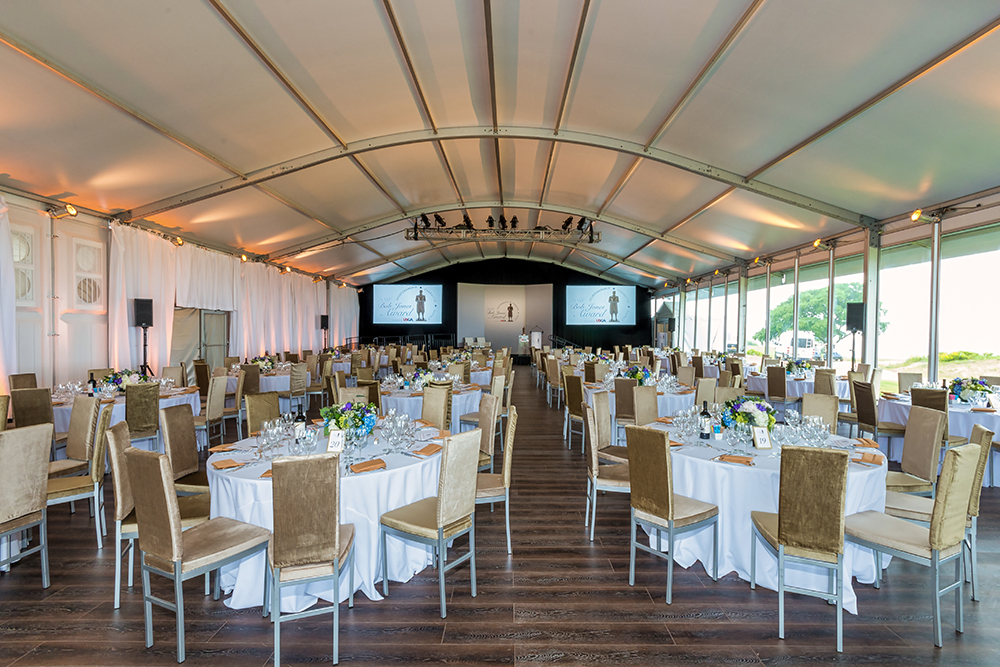 tables and chairs on a hardwood floor inside an arcum structure