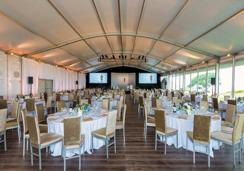 tables and chairs on a hardwood floor inside an arcum structure